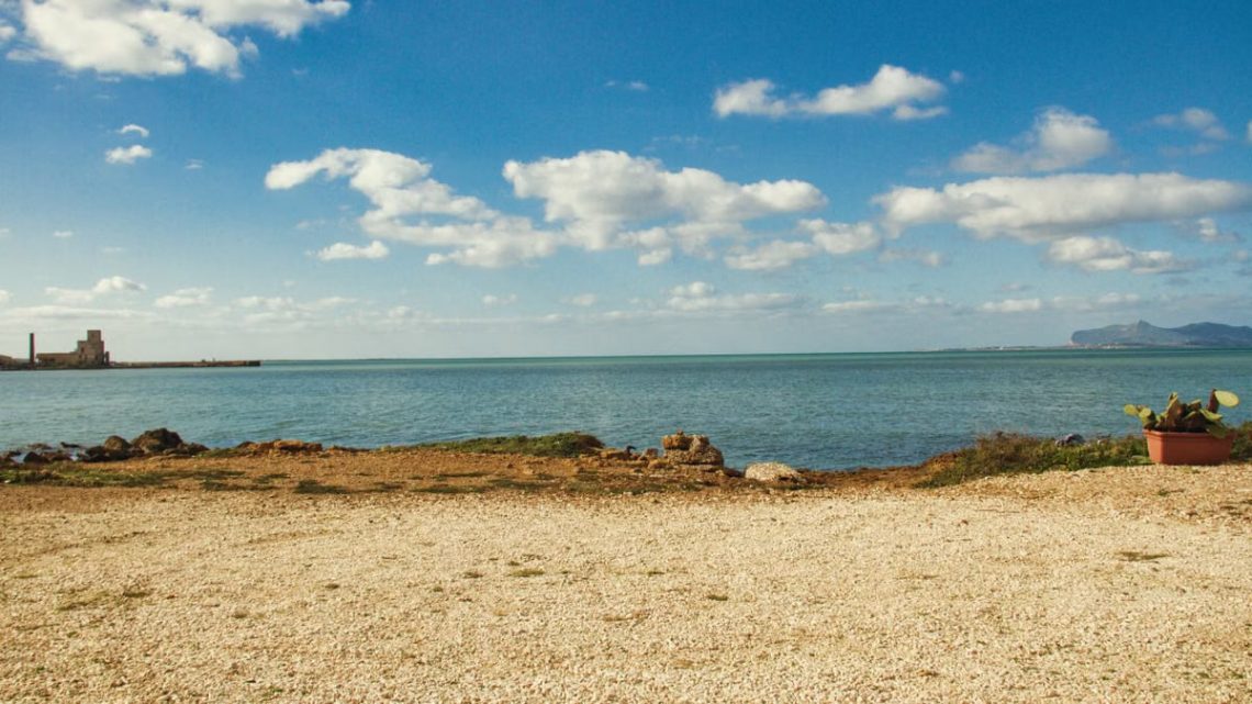 Tranquil view of the coastline in Trapani, Sicily with clear blue sky and sea.