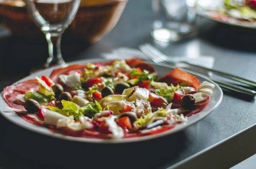 Enticing Mediterranean salad featuring olives, cheese, and fresh vegetables on a ceramic plate.